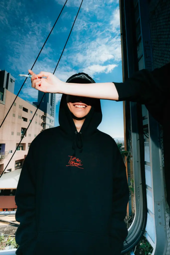 Someone is holding a cigarette above the smiling person.